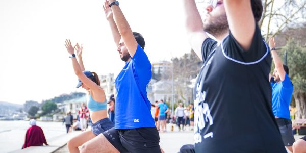 Group performing yoga outdoors along the scenic waterfront in İstanbul, Türkiye.